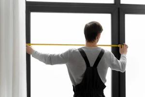 a repairman measuring the impact door and windows at home